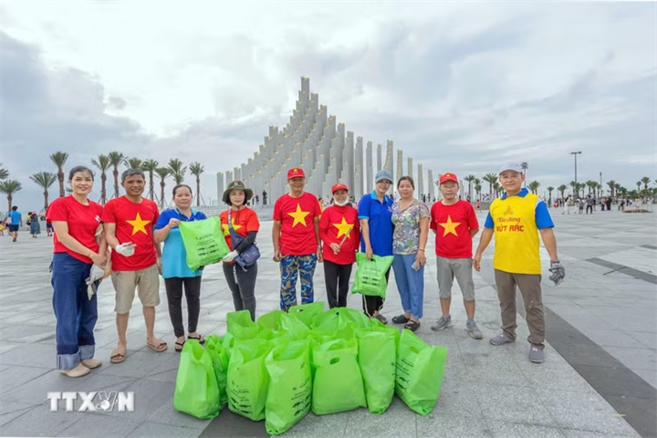 Thu gom và phân loại rác, bảo vệ môi trường. (Ảnh: TTXVN)