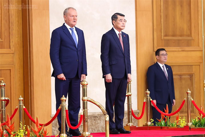 Thủ tướng Lê Minh Hưng và Thủ tướng Donald Tusk trên bục danh dự nghe Quân nhạc cử Quốc thiều hai nước - Ảnh: chinhphu.vn/Nhật Bắc