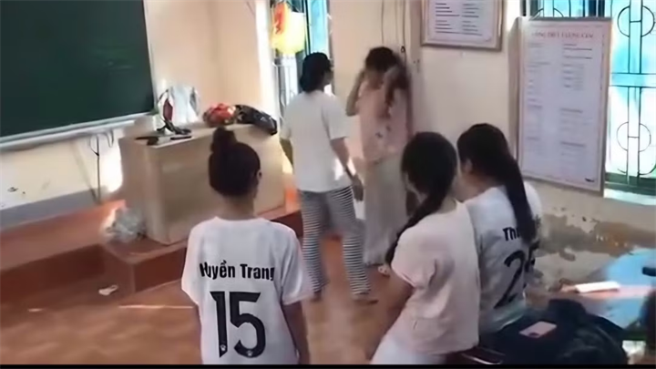 Nữ sinh T.A (mặc áo hồng đứng ở góc tường) đang tập văn nghệ thì bị đánh và bị quay clip đăng lên mạng xã hội. Ảnh: Công an Nhân dân