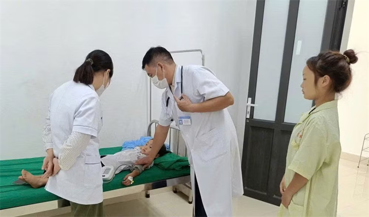 Bác sĩ ở Trung tâm Y tế Nậm Pồ khám, điều trị cho trẻ mắc bệnh quai bị. (Ảnh: LÊ LAN/Nhân dân)